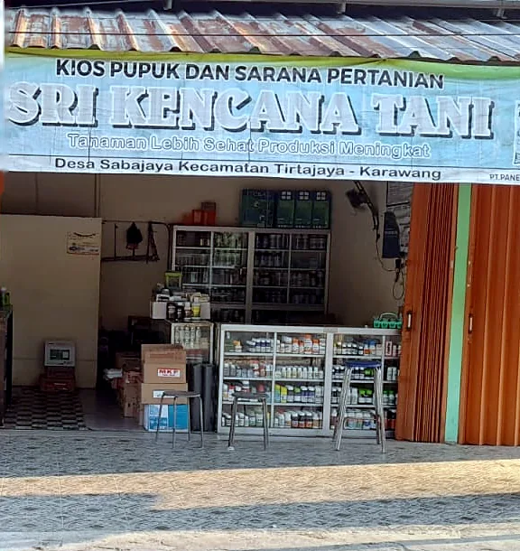 Tampak depan kios Sri Kencana Tani dengan rolling door oranye