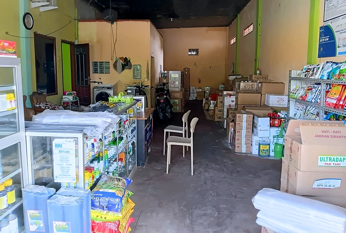 Ruang dalam toko Sri Tani dengan rak pestisida, benih, dan tumpukan pupuk